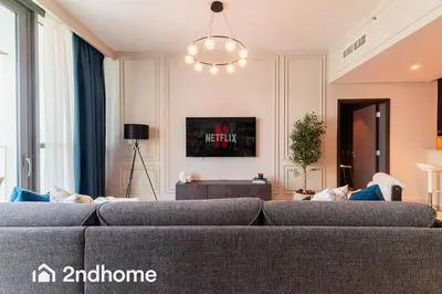 a living room with a couch and a chandelier at 2ndHome - Downtown Views 1 in Dubai