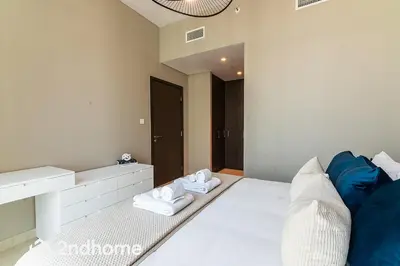 a bedroom with a white bed with towels on it at 2ndHome - Downtown Views 1 in Dubai