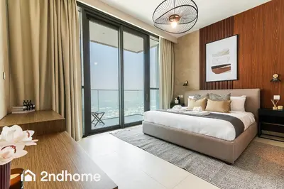 a bedroom with a bed and a large window at 2ndHome - Downtown Views 1 in Dubai