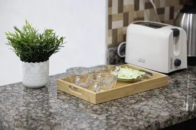a wooden tray with glasses on a counter with a toaster at Luxury 1-BR with Lake View in Business Bay in Dubai