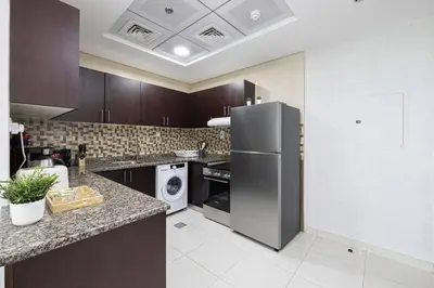 a kitchen with a refrigerator and a dishwasher at Luxury 1-BR with Lake View in Business Bay in Dubai