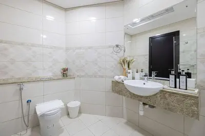 a white bathroom with a sink and a toilet at Luxury 1-BR with Lake View in Business Bay in Dubai