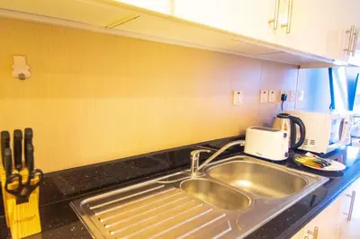 a kitchen with a sink and a toaster on a counter at Cozy Studio Apartment in DIFC in Dubai