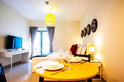 a room with a table with plates and wine glasses at Cozy Studio Apartment in DIFC in Dubai