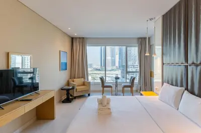 a hotel room with a large bed and a television at Canal View l Hotel Studio l Great Amenities in Dubai