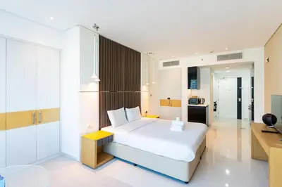 a bedroom with a white bed and a desk at Canal View l Hotel Studio l Great Amenities in Dubai