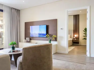 a living room with a couch and a tv at Renovated 1BR Haven in 5 Star Resort in Dubai