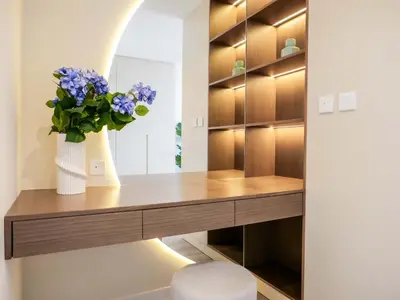 a dressing room with a desk with a vase of flowers at Renovated 1BR Haven in 5 Star Resort in Dubai