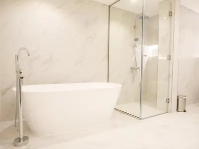 a white bathroom with a tub and a shower at Renovated 1BR Haven in 5 Star Resort in Dubai
