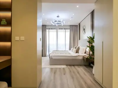 a bedroom with a large bed and a chandelier at Renovated 1BR Haven in 5 Star Resort in Dubai