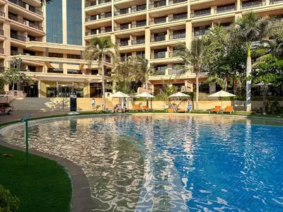 a large swimming pool in front of a large building at Renovated 1BR Haven in 5 Star Resort in Dubai