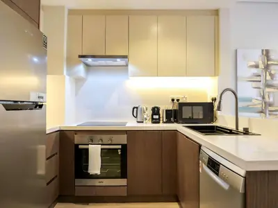 a kitchen with a stove and a microwave at Renovated 1BR Haven in 5 Star Resort in Dubai