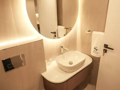 a bathroom with a white sink and a mirror at Stunning Renovated 1BR Apartment at 5 Star Resort in Dubai