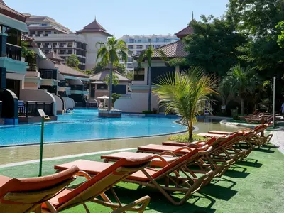 a row of lounge chairs next to a swimming pool at Stunning Renovated 1BR Apartment at 5 Star Resort in Dubai