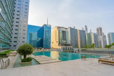 a large swimming pool in a city with tall buildings at Majestine business bay in Dubai