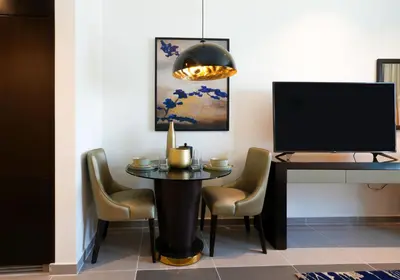 a dining room with a table and a tv at Majestine business bay in Dubai