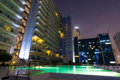 a pool in the middle of a city at night at Majestine business bay in Dubai