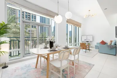 a dining room with a table and chairs and windows at New Ultimate Stay 5 min walk from Dubai Mall Lofts Tower 5 pax in Dubai