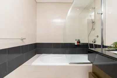 a bathroom with a bath tub and a shower at New Ultimate Stay 5 min walk from Dubai Mall Lofts Tower 5 pax in Dubai