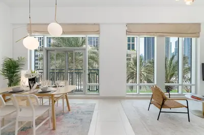 a dining room with a table and chairs and large windows at New Ultimate Stay 5 min walk from Dubai Mall Lofts Tower 5 pax in Dubai