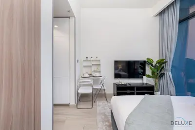 a bedroom with a bed and a desk and a table at Inviting Studio Apartment at Azizi Riviera 36 in Al Merkadh by Deluxe Holiday Homes in Dubai