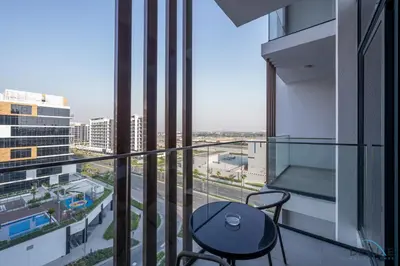 a balcony with a table and chairs in a building at Inviting Studio Apartment at Azizi Riviera 36 in Al Merkadh by Deluxe Holiday Homes in Dubai