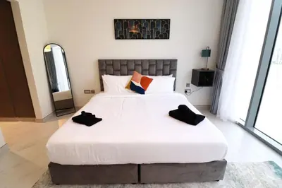 a bedroom with a large white bed with two pillows at Stellar Dreams 1BR - District 1 in Dubai