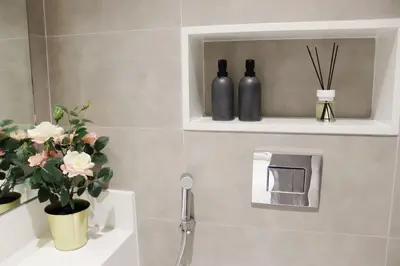 a bathroom with a sink and two bottles on a wall at Stellar Dreams 1BR - District 1 in Dubai