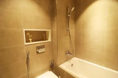 a bathroom with a shower and a tub and a sink at Stellar Dreams 1BR - District 1 in Dubai