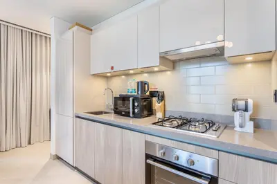 a kitchen with white cabinets and a stove top oven at STAY BY LATINEM Luxury 2BR Holiday Home W204 near Burj Khalifa in Dubai