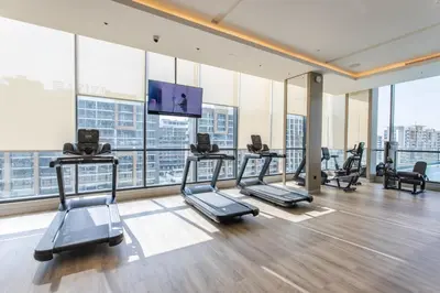 a gym with several treadmills and a flat screen tv at STAY BY LATINEM Luxury 2BR Holiday Home W204 near Burj Khalifa in Dubai