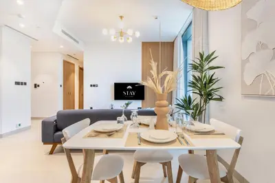 a dining room with a white table and chairs at STAY BY LATINEM Luxury 2BR Holiday Home W204 near Burj Khalifa in Dubai