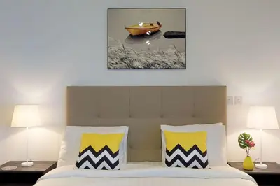 a bedroom with a bed with yellow and white pillows at Comfy Studio Apartment in DIFC in Dubai