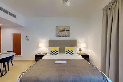 a bedroom with a large bed and a table at Comfy Studio Apartment in DIFC in Dubai