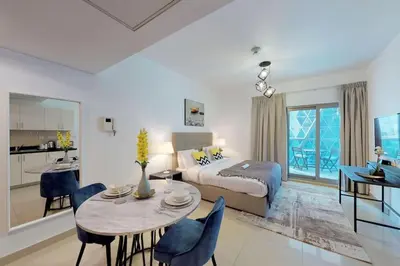a bedroom with a bed and a table with chairs at Comfy Studio Apartment in DIFC in Dubai