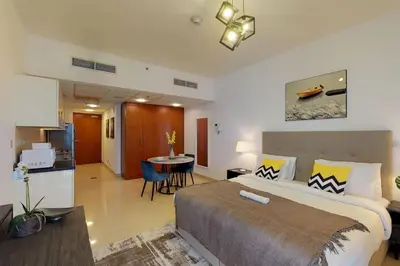 a bedroom with a large bed and a kitchen at Comfy Studio Apartment in DIFC in Dubai