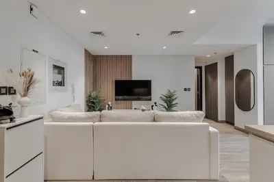 a living room with a white couch and a tv at Modern Studio with Pool View & Gym Access in Dubai