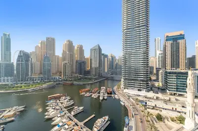 a group of boats docked in a river in a city at Marina-View 1BR Escape Walk to Dining & Landmarks in Dubai