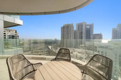 a table and chairs on a balcony with a view of a city at Marina-View 1BR Escape Walk to Dining & Landmarks in Dubai