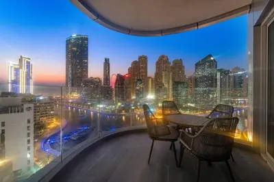 a balcony with a table and chairs and a city skyline at Marina-View 1BR Escape Walk to Dining & Landmarks in Dubai
