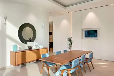 a dining room with a wooden table and blue chairs at Luxury 4BR Flat, Downtown Dubai, Pool, Gym, PS5, Sleeps 11 Guests in Dubai