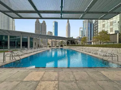 a large swimming pool with chairs and a building at FIRST CLASS 1BR Luxury Living in DIFC in Dubai