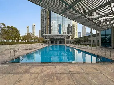 a large swimming pool with chairs and a building at FIRST CLASS 1BR Luxury Living in DIFC in Dubai
