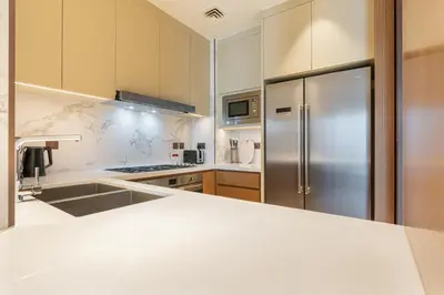 a kitchen with a stainless steel refrigerator at Deluxe 3BR Home in Address Opera with Full Burj View in Dubai