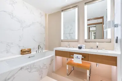 a bathroom with a tub and a sink and a mirror at Deluxe 3BR Home in Address Opera with Full Burj View in Dubai