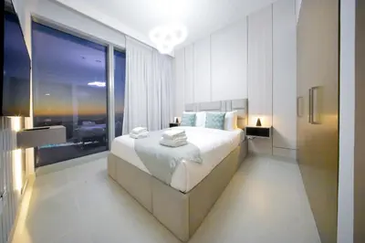 a bedroom with a large bed and a large window at PrimeForte Walk to Dubai Mall in Dubai