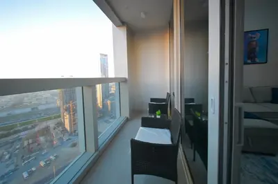 a room with a balcony with a view of a city at PrimeForte Walk to Dubai Mall in Dubai
