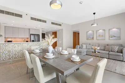 a dining room and living room with a table and chairs at Luxurious Living 3 Bedroom at Harbour Views in Dubai