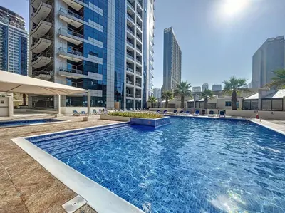 a large swimming pool in a city with tall buildings at Bay Central 2 - Charming One Bedroom in Dubai