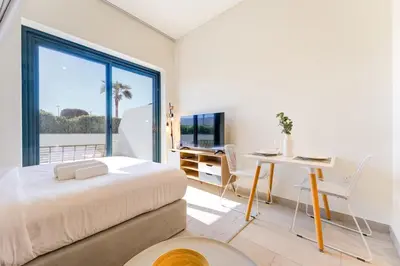 a bedroom with a bed and a desk and a window at Azizi Riviera 46 - Cosy Studio in Dubai